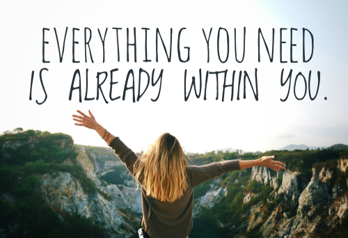 Frau steht in der Natur, reißt Arme hoch, Schriftzug Everything you need is already within you.