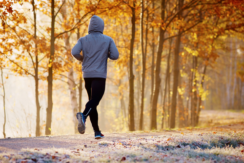 Mann, der im Winter oder Herbst Outdoor im Schnee trainiert und joggt.