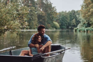 Liebespaar, Frau und Mann umarmen sich im Boot auf einem See im Park.